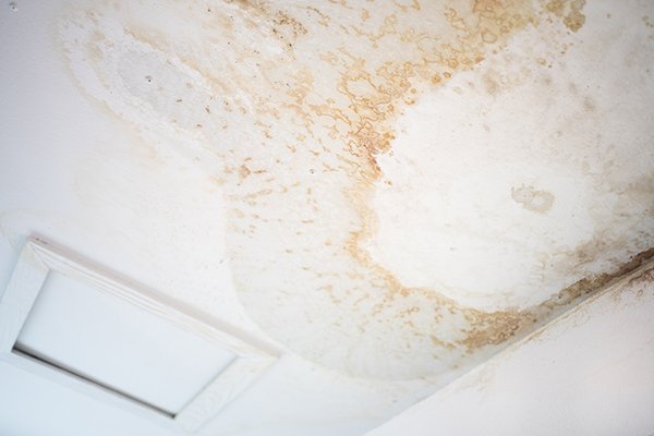 Peeling paint on an interior ceiling a result of water damage