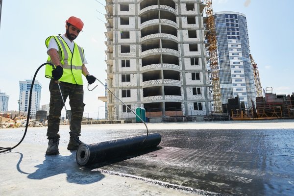 contractor welding a flat roof membrane on a flat roofed property