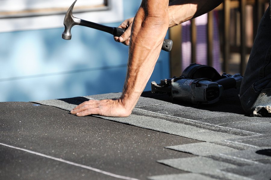 a roofer working on repairing a damaged roof